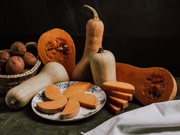 Still life of ripe nutmeg pumpkin and sliced butternut squash