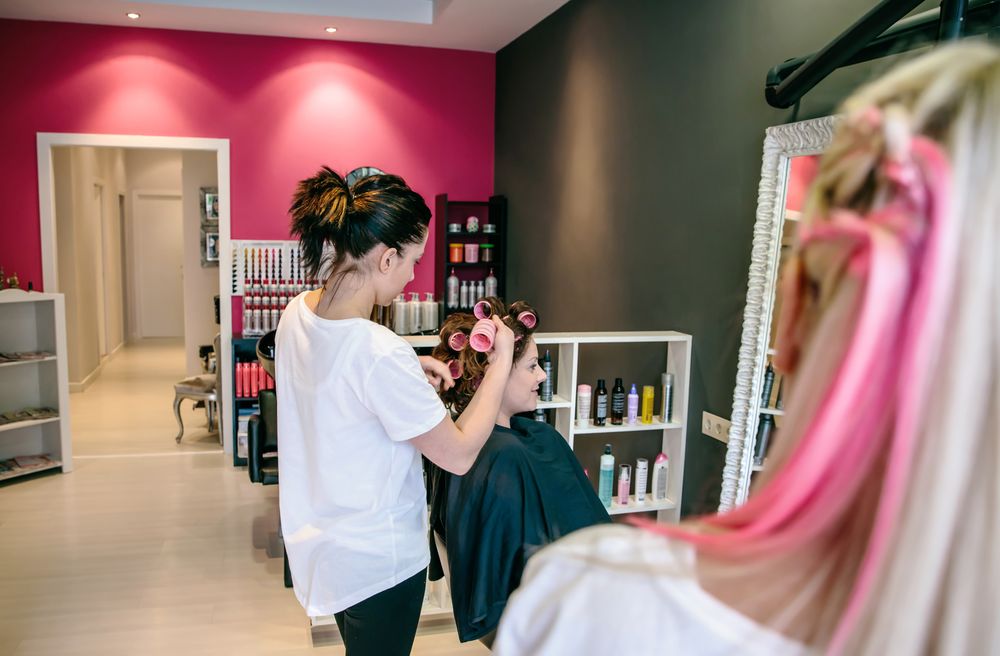 Hairdresser putting curlers into client