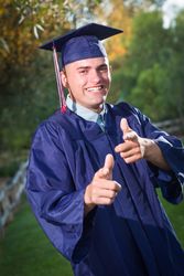 Male Graduate in Cap and Gown Outside.