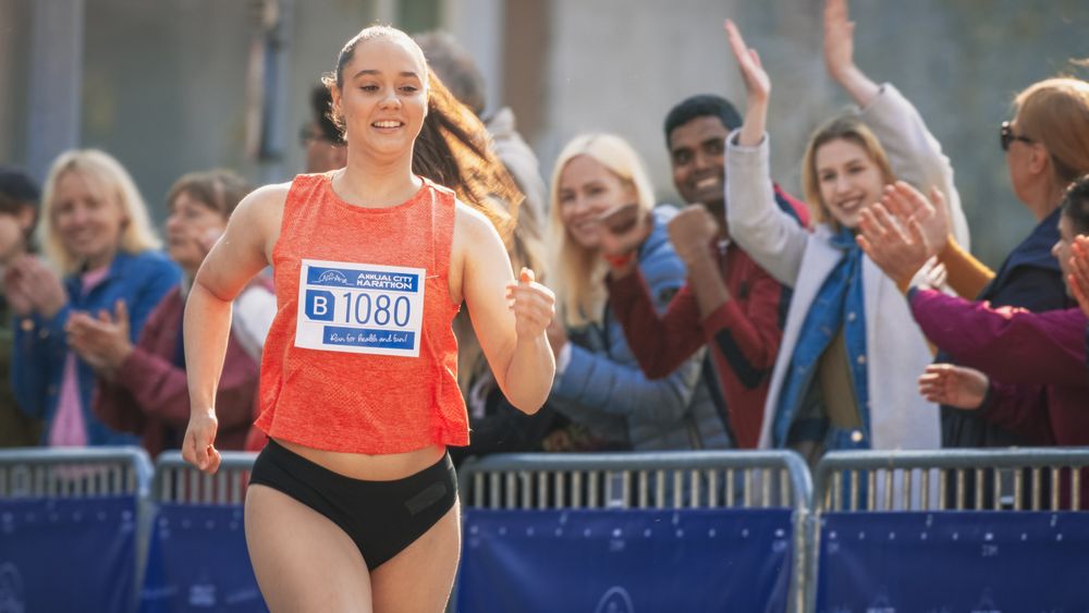 Strong Athletic Female Jogger Racing Other Runners with Determination for the First Place in the Finish Line