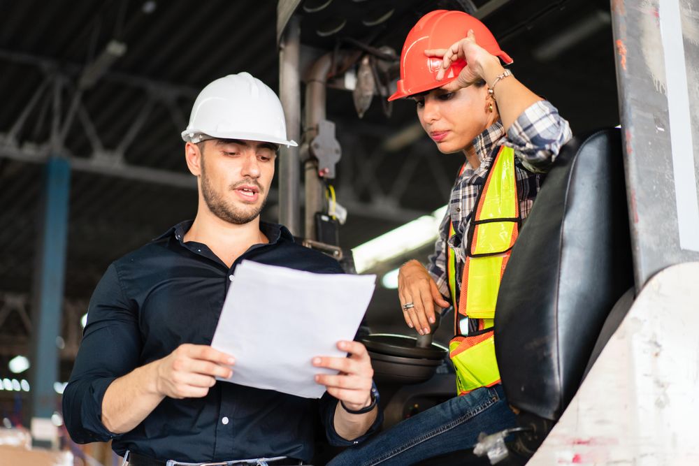 Two colleagues reviewing documents for work in distribution center