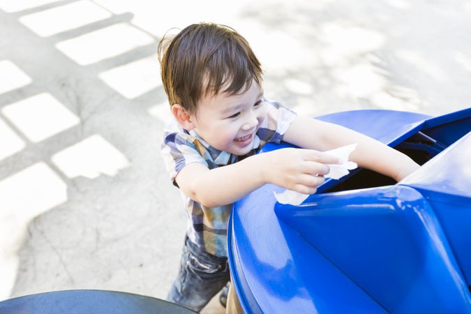 Cute Biracial Boy Placing Paper Into Recycle Bin