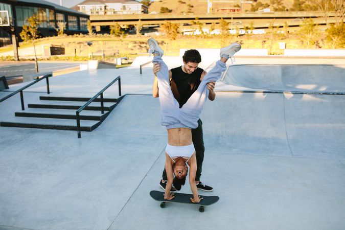 Couple having fun with skateboard at skate park