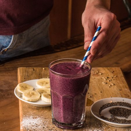 Person mixing purple smoothie drink