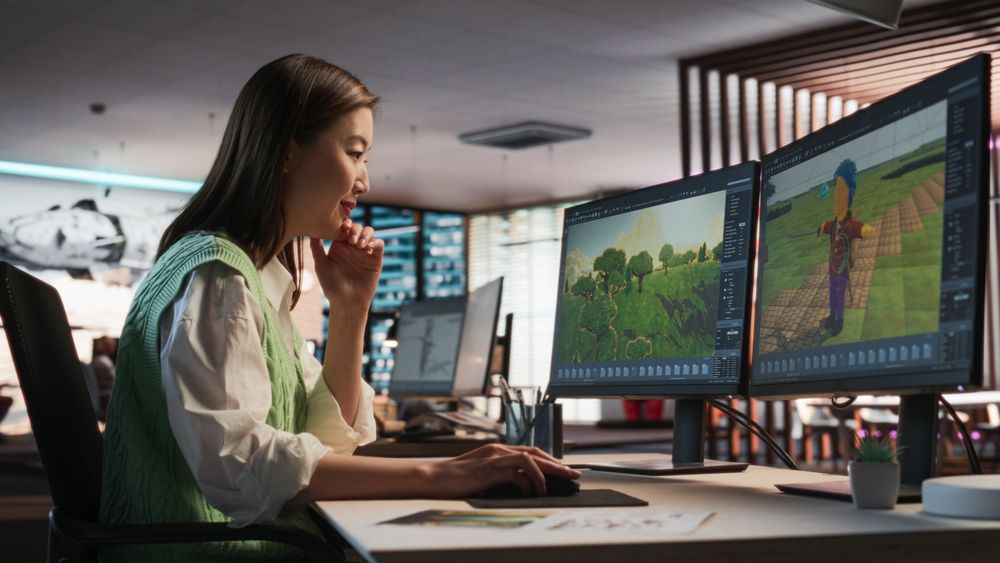 Female Asian Game Designer Using Desktop Computer, Designing Unique World And Characters In 3D modelling Software For RPG Video Game.