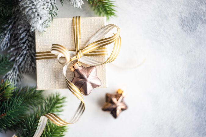 Top view of Christmas present with gold ribbon and star decorations
