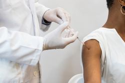 Doctor making injection for Black woman patient