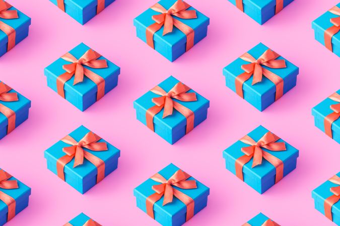 Blue gift boxes with pink ribbon on pink background
