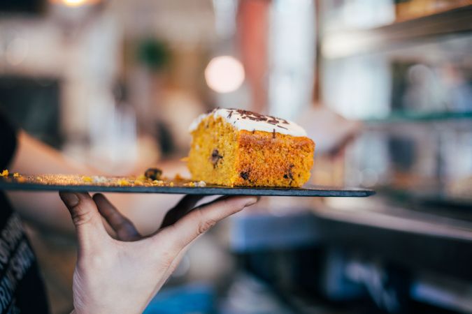 Hand holding up dessert tray with carrot cake