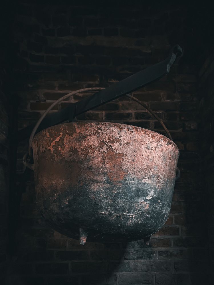 Cast iron cauldron hanging in fireplace