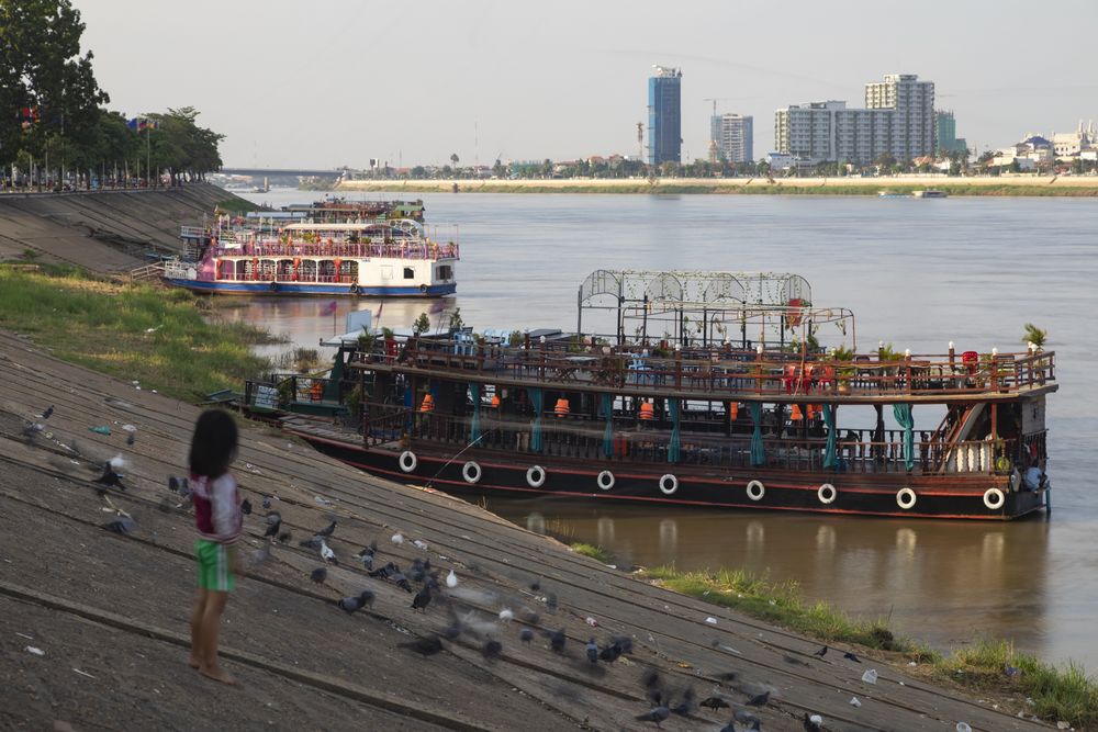 Phnom Penh, Cambodia - Nov 18, 2019: A little girl watches the boats at Tonle Sap River