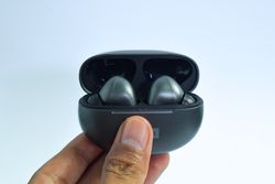 Hand holding earbuds in case