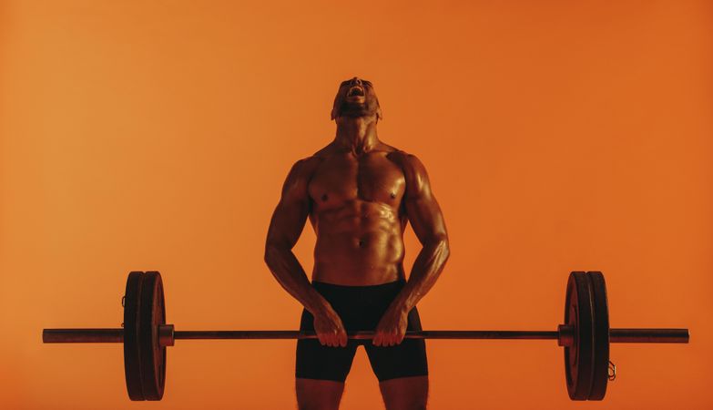 Tough shirtless male lifting heavy weights