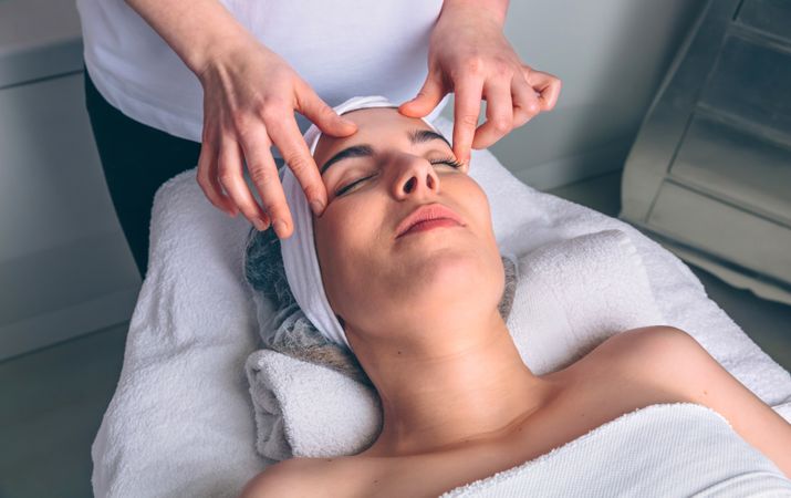 Woman receiving a relaxing facial massage on forehead