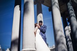 Newlyweds kissing near columns