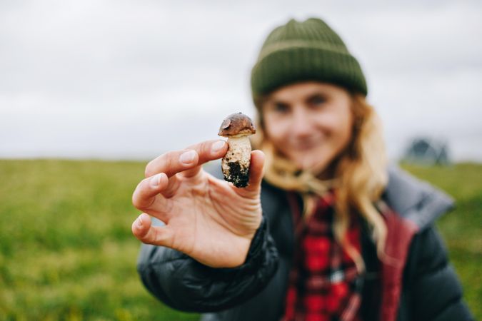 Woman holding up foraged mushroom