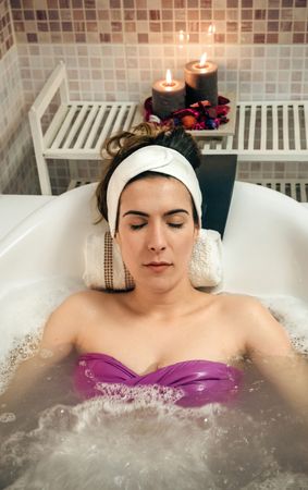 Woman resting in therapeutic bath in spa