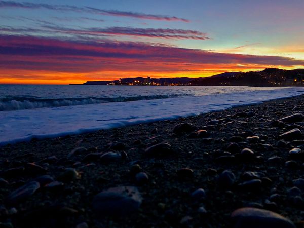 Small stones on beach shore during sunset