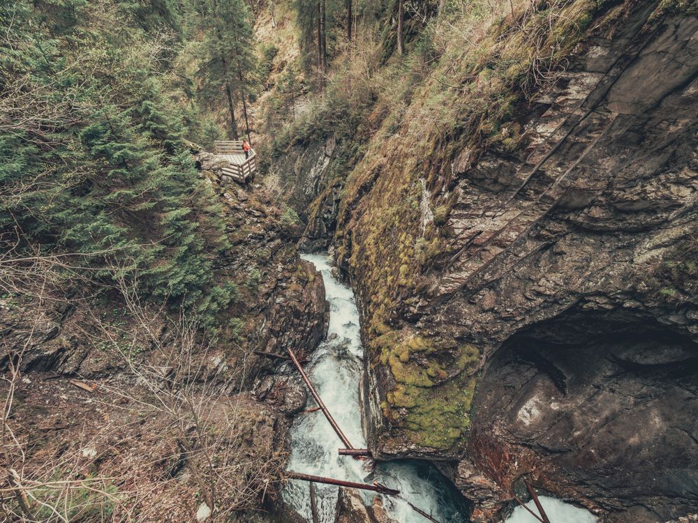 Traveller admiring picturesque view of mountain stream