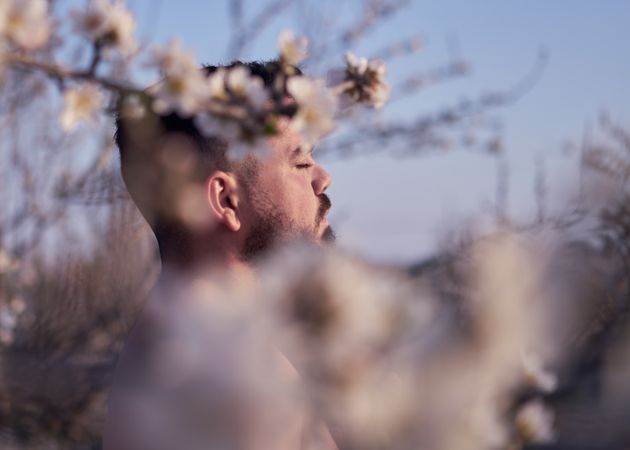 Shirtless man meditating in spring garden