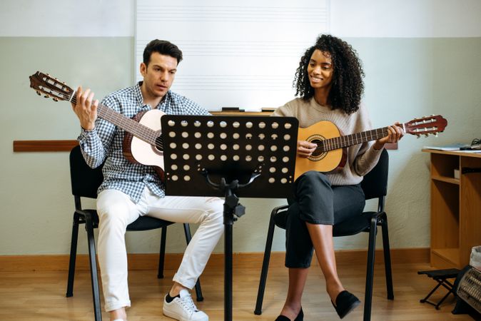 Man and woman playing guitar in studio