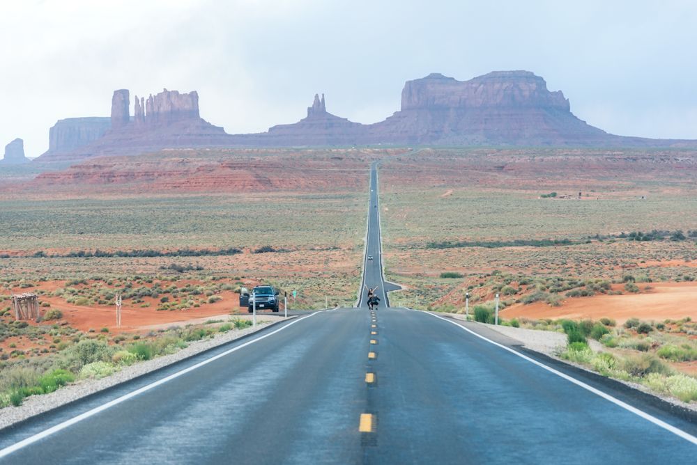 Asphalt road at scenic mountain valley and power line