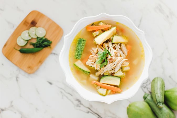 Served chicken soup with carrot and zucchini