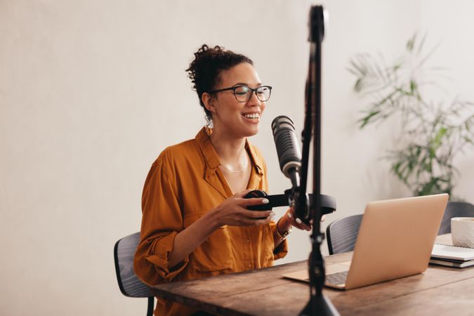 Woman recording and broadcasting her podcast from home