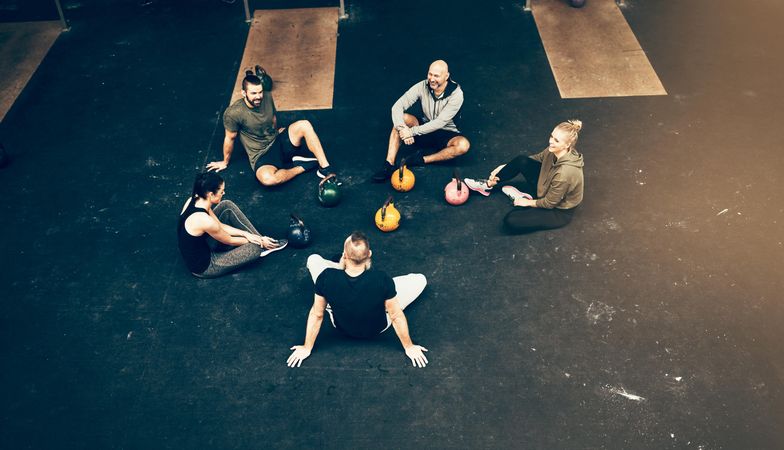 Group of people sitting on gym floor