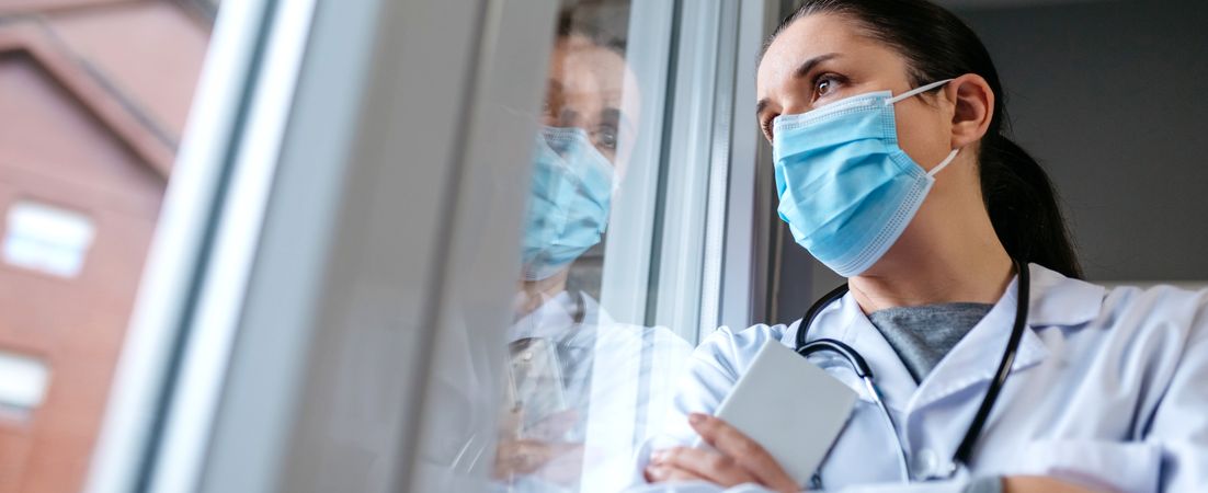 Female doctor looking out the hospital window