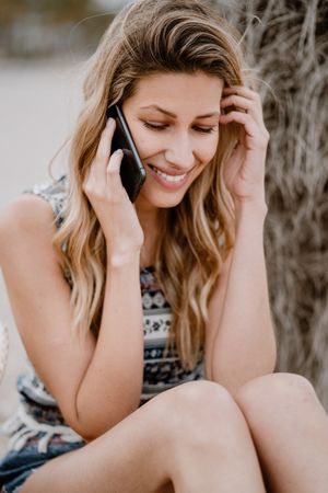 female talking on smartphone on beach