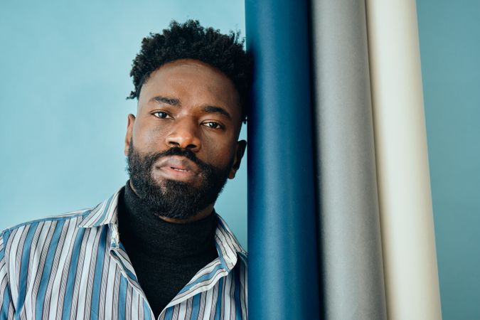 Portrait of Black bearded man in striped blue shirt and turtleneck