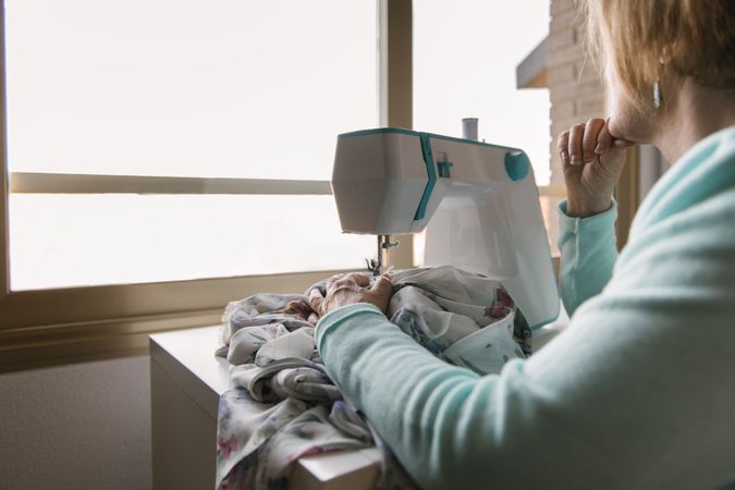 Mature woman using sewing machine