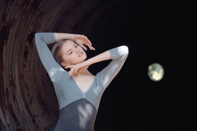 Graceful woman dancing in dark tunnel