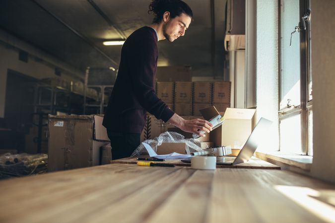 Business owner packing online order to delivery