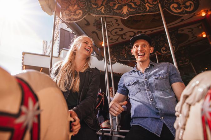 Smiling friends on amusement park carousel