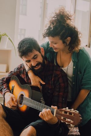 Cheerful couple playing guitar
