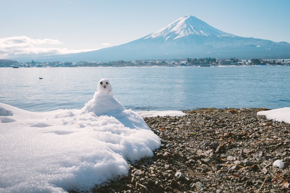 Snowman standing in winter landscape on fuji moutain background at kawaguchiko lake, Japan