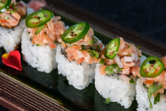 Appetizing sushi rolls served with salmon in tray