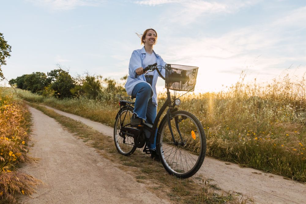 blonde woman on a bike during sunset in a field