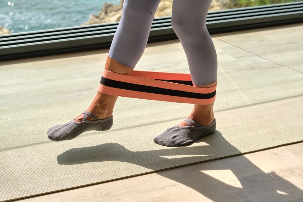Female training with resistance band in sunlight