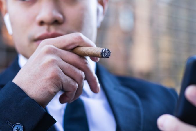 Businessman smoking cigar in street cafe