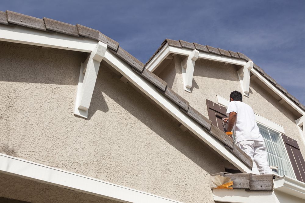 House Painter Painting the Trim And Shutters of Home