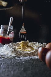 Cook preparing dough with egg and flour