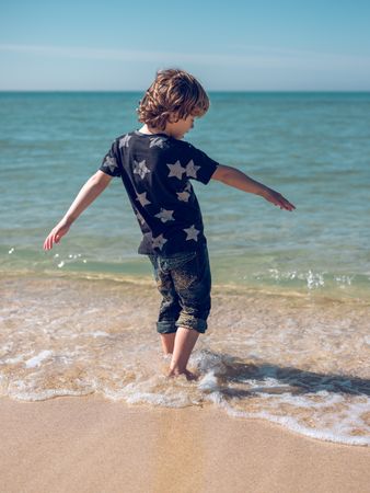 Boy walking in sea water