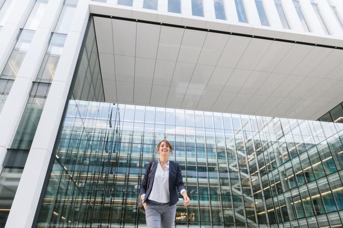 Happy female manager walking from work
