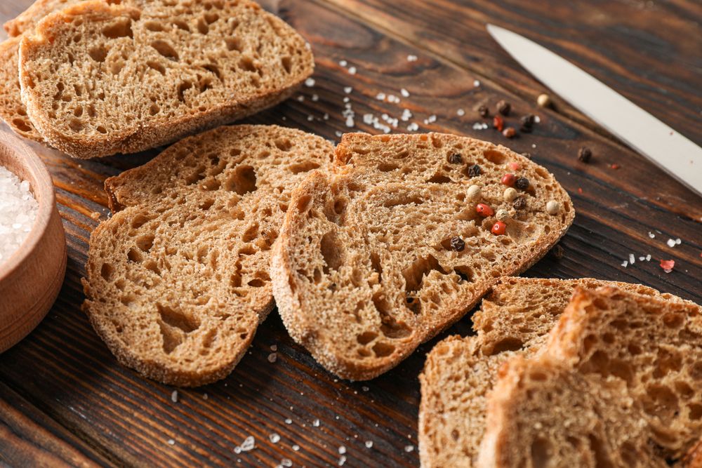 Flat lay composition with freshly baked bread on wooden background, closeup and space for text