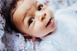 Portrait of baby boy with huge eyes and curly hair
