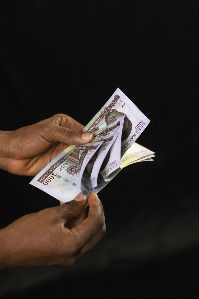 Cropped image of counting 1000 Nigerian Naira cash papers