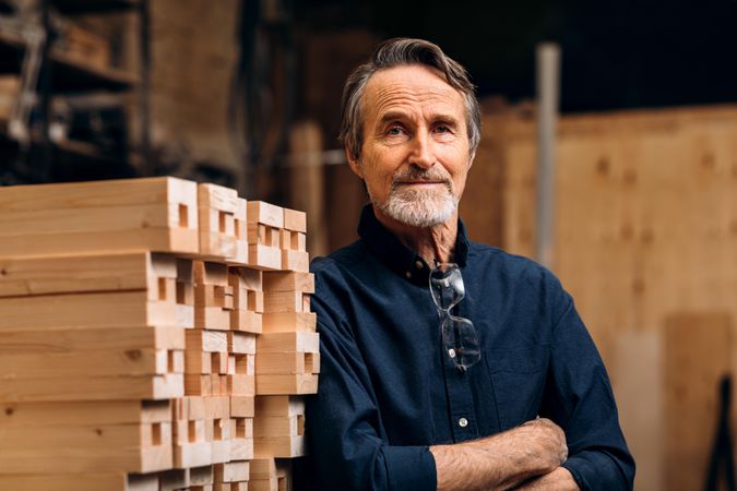 Proud carpenter in his woodworking shop